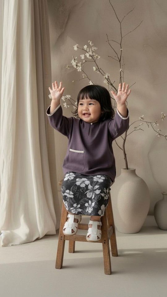 Child on a stool with outstretched arms in a room with neutral decor